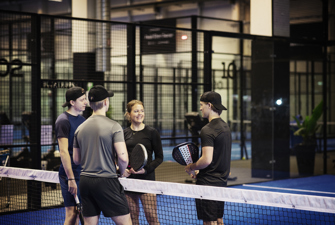 Mennesker snakker på en padelbane